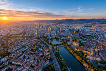 Fototapeta premium Sunset cityscape with river and distant mountains