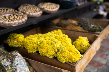 Small yellow wildflowers displayed at a market, showcasing natural beauty, vibrant color, and fresh floral arrangements for sale in a lively setting.