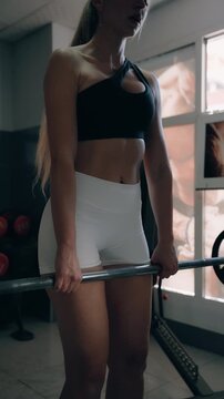 Athletic woman performing romanian deadlifts with barbell in gym, focusing on glutes and hamstrings for strength training and muscle growth, concept of fitness and bodybuilding