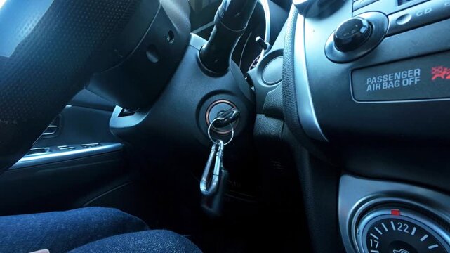 man turns car key to start engine