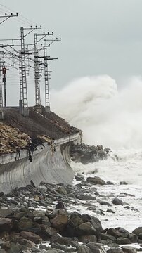 Assessing structural shoreline risk. Teams inspect erosion impact on infrastructure at stormy shoreline. Personnel analyze damage to seaside structures amid turbulent weather conditions