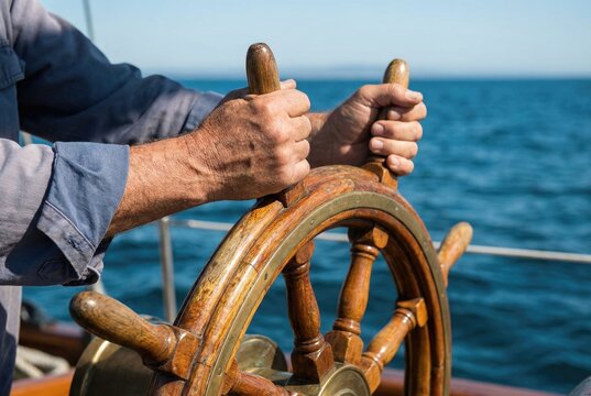 Sailor hands firmly gripping the wooden spokes of a classic ship steering wheel at sea
