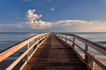 Obraz premium Scenic Wooden Pier at Zingst Beach Over Baltic Sea at Sunset