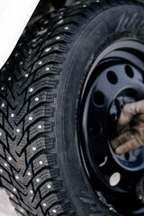 Changing winter tire on snowy ground during cold‑weather vehicle maintenance