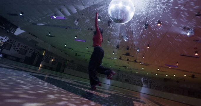 Cute, professional female skater landing awesome splits move on empty disco floor