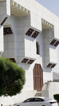 Explore the exterior of Masjid Aisha (Taneem Mosque) in Makkah, featuring modern white marble architecture, intricate wooden carvings, and the official sign marking this historic Miqat site.