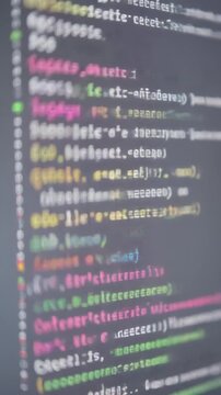Programmer writing code on computer screen with blurred background