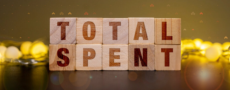 Wooden blocks spelling total spent for personal budgeting and household expense tracking