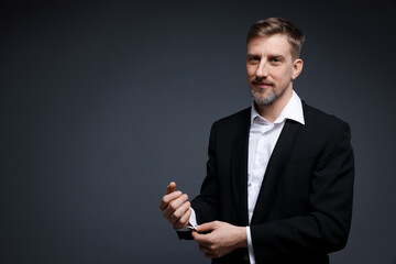 Handsome man in suit on grey background. Space for text