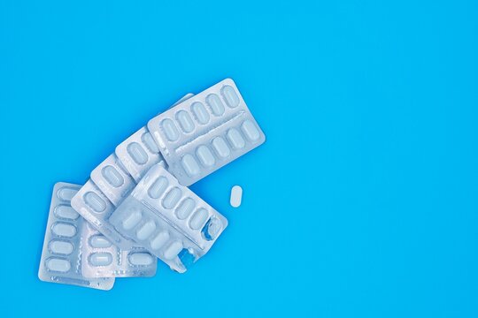 One Medication White Pill Out Of Aluminum Foil Packaging Background Copy Space Right Side