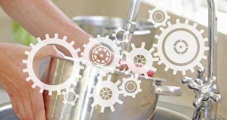 Person washing steel pot at sink under running faucet, rinsing, prepping meal with gear overlay