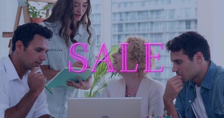 Presenting woman in blazer showing teal folder to colleagues at laptop in office with neon SALE