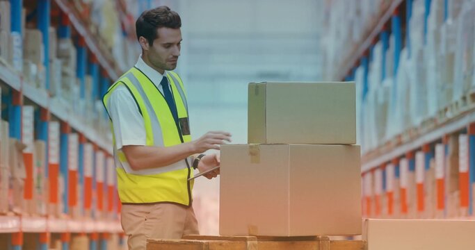 Scanning warehouse worker wearing high-visibility vest and tie, using handheld scanner on boxes
