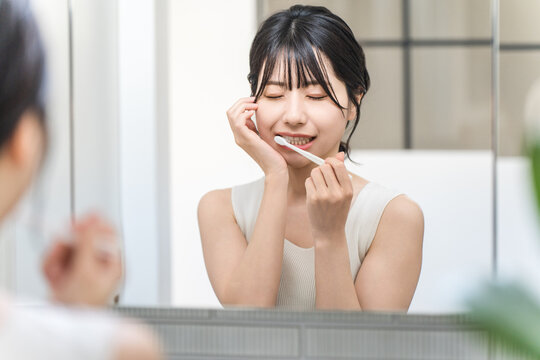 Young Asian woman suffering from tooth decay, tooth sensitivity and periodontal disease after brushing her teeth
