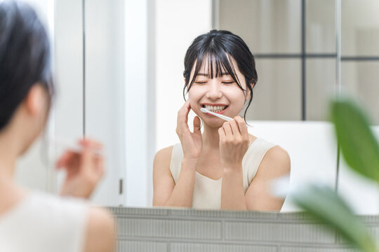 Young Asian woman suffering from tooth decay, tooth sensitivity and periodontal disease after brushing her teeth