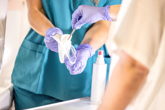Nursing instructor receiving sterile gauze compress with forceps during clinical wound care training