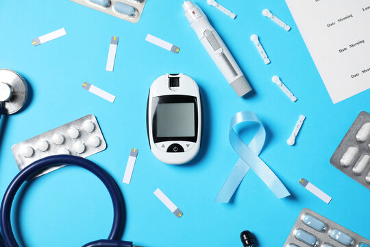 Diabetes. Flat lay composition with digital glucometer, test strips, lancets and pen on light blue background