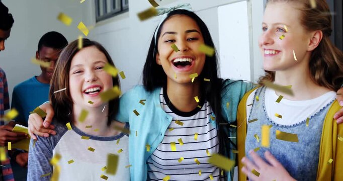Gold confetti falling sparking three female students laughing, leaning in, celebrating school win