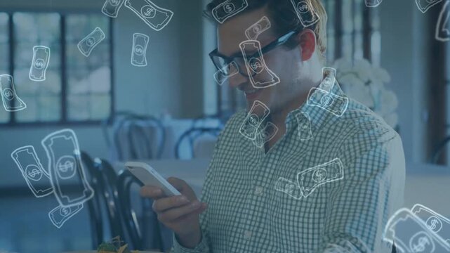 Man sitting at dining table, tapping phone, showing money art near plate while checking finance app