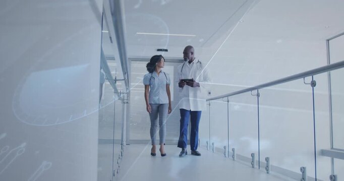 Vertical video: From door, Dr in lab coat walking with tablet while peer discussing data in clinic