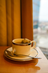 Fototapeta premium Close up of a fresh cup of hot herbal tea with a tea bag in a white ceramic mug.