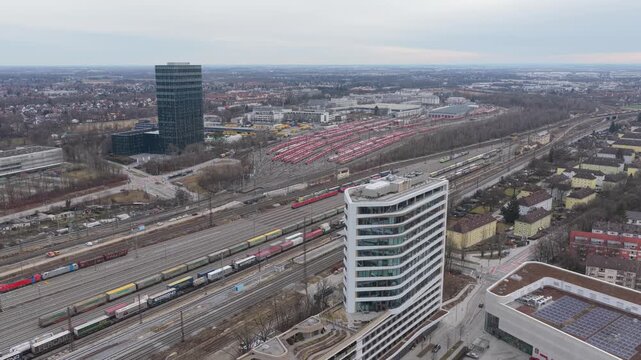 Aerial view over a Munich train yard featuring organized rows of trains and intersecting railway lines.