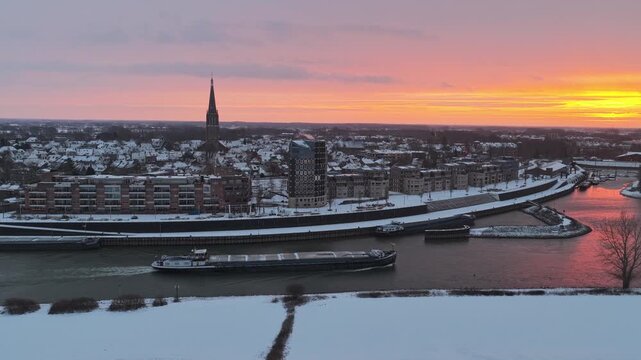 Aerial view of Doesburg, Netherlands, during a colorful winter sunrise with a snowy landscape and glowing horizon.