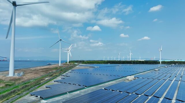 Aerial view of a hybrid power plant with wind turbines and solar panels