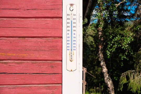 Outdoor Thermometer on Red Wooden Wall Showing Summer Temperature in Lapland Sweden