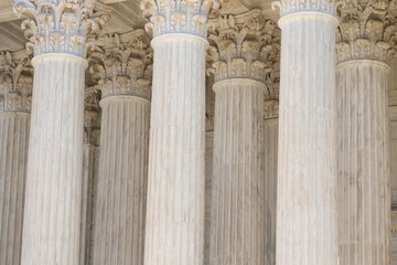 Naklejka premium Supreme Court columns symbolize authority. Classical facade with massive pillars. Government building with timeless architecture. Court house exterior with elegant columns.