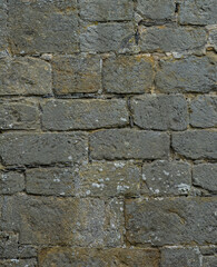 Fototapeta premium Medieval limestone stone wall background with weathered architectural texture