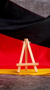 Paper note with words TAX on National symbol of Germany. German wave silky flag background. Concept of tax planning system and economy policy 