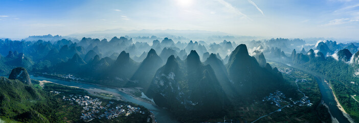 Naklejka premium Aerial view of the Li River and iconic karst mountains shrouded in morning mist in Yangshuo, Guilin, China.