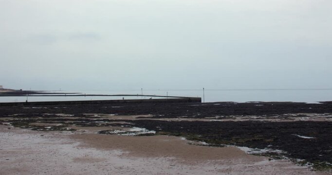 Wide panning shot right to left of walpole tidal pool at low tide. At Margate.
