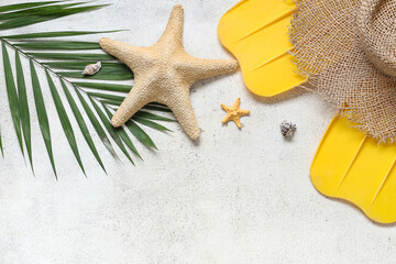 Beautiful composition with hat, palm leaf, flippers and starfish on white grunge background © Pixel-Shot