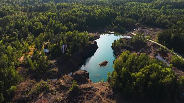 Panoramic drone shot of a turquoise lake, copper ore, at sunny Orajarvi, Finland