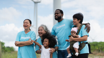 Group of Volunteers Walking Near Wind Turbines During Environmental Charity and Community Outreach...