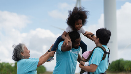 Group of Volunteers Walking Near Wind Turbines During Environmental Charity and Community Outreach...