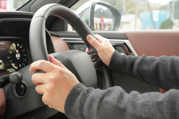 A driver holding the steering wheel of a car