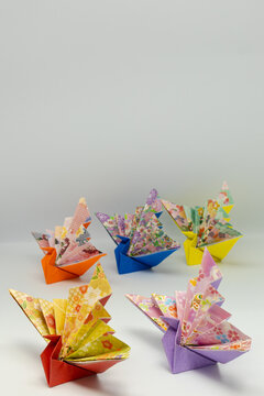 Colorful origami cranes on minimal background