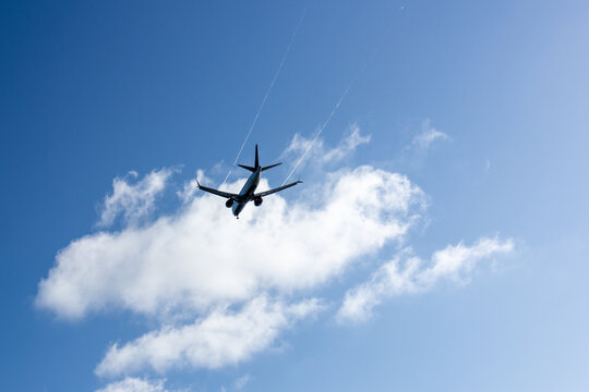 Commercial jet flying through white clouds in a blue sky at Iona Beach Regional Park in Vancouver Canada