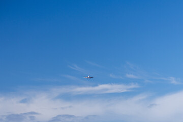 Fototapeta premium Commercial airplane descending for landing against a cloudy sky at Iona Beach Regional Park in Vancouver Canada