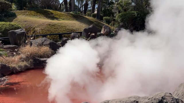 Dramatic blood-red hot spring with thick white steam and erupting sounds at Chinoike Jigoku in winter, Beppu, Oita, Japan (4K)
