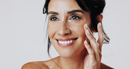 Skincare, smile and touching with happy woman in studio for cosmetic or dermatology inspiration. Beauty, ideas and satisfaction with mature model isolated on white background for antiaging aesthetic