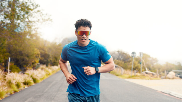 Fitness, running or man with sunglasses, outdoor or training for health benefits, cardio or workout. Nature, runner or person in street, eyewear or practice for wellness or shades for uv protection