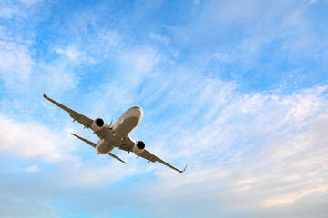 White passenger airplane flying in the sky amazing clouds in the background - Travel by air transport