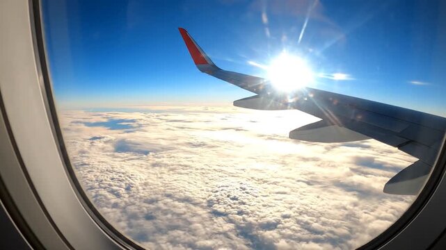 Airplane wing soaring above a vast expanse of f white clouds under a bright