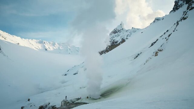 Steam vent rising in snowy alpine valley, overview