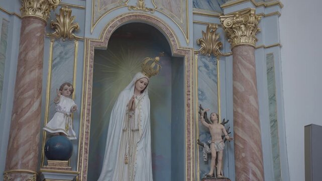 Catholic Virgin Mary statue displayed in decorative church altar niche
