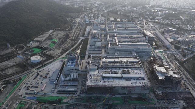 High aerial view showing the massive scale of an industrial complex or semiconductor manufacturing plant under construction, showcasing the progress of building a modern technology facility